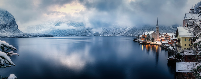 Panoramic view of the lake and village of Hallstatt during a winter day with snow and ice in the Austrian Alps