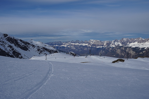 Panoramic view on Pizol winter sport region and resort in Bad Ragaz, Switzerland. On background is sky with lot of copy space and snowcapped Swiss Alps. Mountains make part of tectonic arena Sardona.