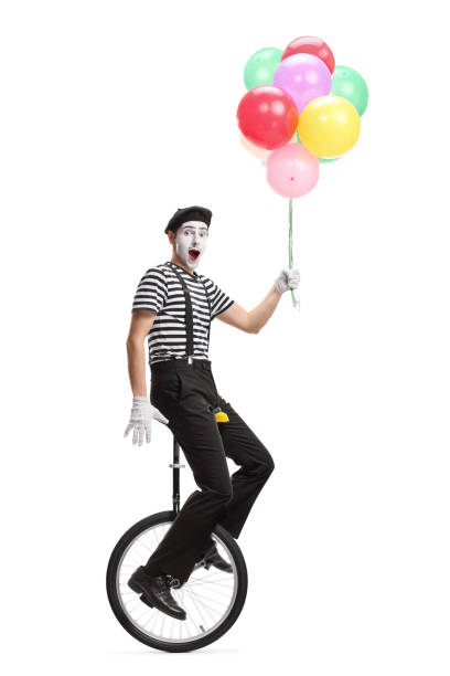 Pantomime man on a unicycle holding a bunch of colorful balloons Full length shot of a pantomime man on a unicycle holding a bunch of colorful balloons isolated on white background charades stock pictures, royalty-free photos & images