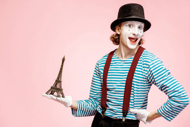 Pantomime with eiffel tower on the pink background Pantomime with white facial makeup posing with Eiffel tower on the pink background. French mime concept mime artist stock pictures, royalty-free photos & images