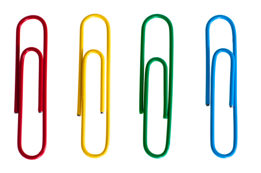 Selection of multi-colored paper clips on isolated white background.