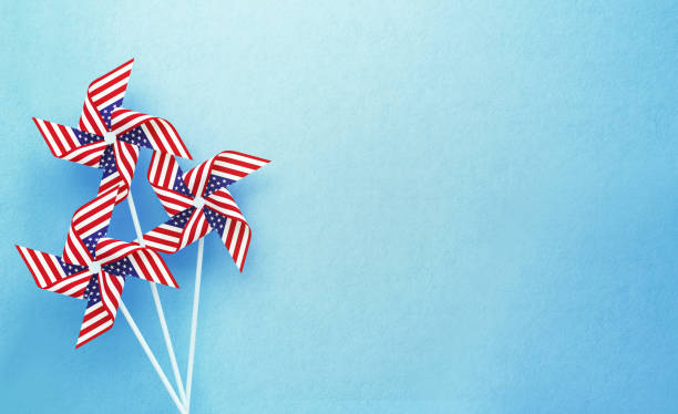 papier pinwheels strukturiert mit amerikanischer flagge auf blauem hintergrund - windrad stock-fotos und bilder
