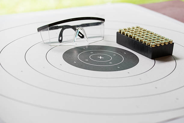 paper shooting target with safety glasses and 9 mm bullet stock photo