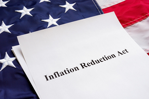 Papeles con la Ley de Reducción de la Inflación y bandera de los Estados Unidos. photo