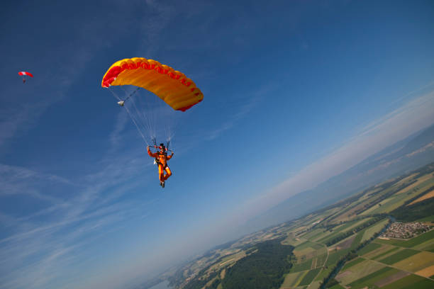 Paraglider glides towards the earth Earth and sky behind parachuting stock pictures, royalty-free photos & images