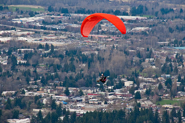 Paraglider Soaring Above Town Tiger Mountain State Forest, Washington, USA - March 07, 2012: A paraglider soars above the town of Issaquah. jeff goulden paragliding stock pictures, royalty-free photos & images