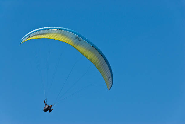 Paragliding in Clear Blue Sky Issaquah, Washington State, USA - May 9, 2016: A man is paragliding in the clear blue sky. jeff goulden paragliding stock pictures, royalty-free photos & images