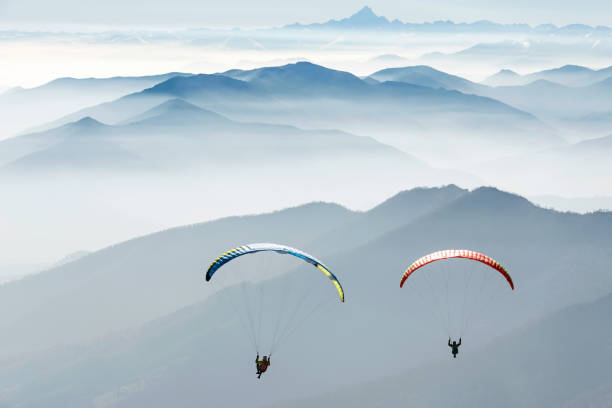paragliding on the mountains couple flying over the mountains, italian Alps. Italy paragliding stock pictures, royalty-free photos & images