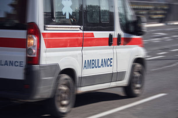 Paramedic 911 ambulance car running fast through the big city. stock photo