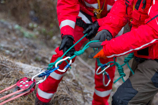 Paramedics mountain rescue service Paramedics from mountain rescue service provide first aid during a training for saving a person in accident in the forest. Unrecognizable people witj ropes and carabiners. rescue stock pictures, royalty-free photos & images