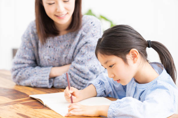 勉強する親と娘 - 勉強する ストックフォトと画像