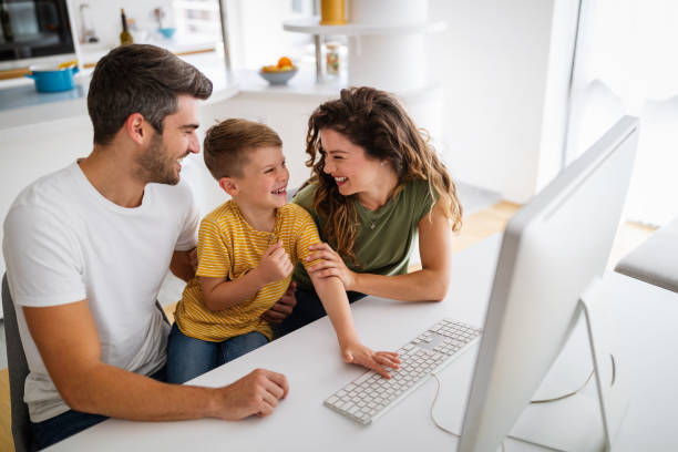 Parents helping to children studying online at home. Lockdown and online school, technology concept. stock photo