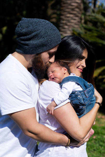 Parents hold the child in their arms. A little child with parents. stock photo