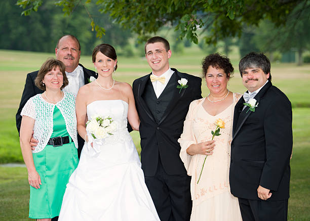 Parents of the Bride and Groom take a Group Portrait Following the wedding ceremony, the mother and father of the bride and groom gather  for a scenic outdoor family portrait. mother of the bride dress stock pictures, royalty-free photos & images