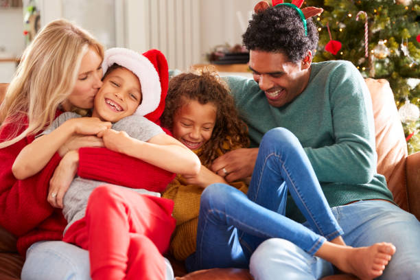 os pais que tickling crianças como a família sentam-se no sofá que comemora o natal junto - natal, familia - fotografias e filmes do acervo