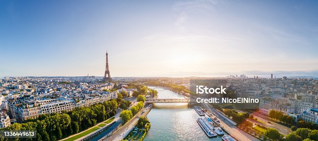 istock Paris aerial panorama with river Seine and Eiffel tower, France. Romantic summer holidays vacation destination. Panoramic view above historical Parisian buildings and landmarks with blue sky and sun 1336449613