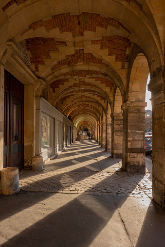Le Marais district. View of arcades of Place des Vosges