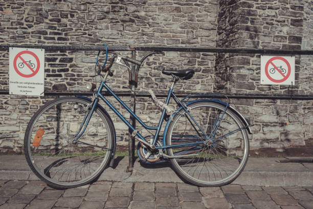 parked bike ignores parking prohibition signs A rusty blue bike parked between 2 parking prohibition signs. Dutch text on 1 of signs says : "Because of safety reaons forbidden to park bikes" rule breaker stock pictures, royalty-free photos & images