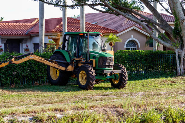 Parked tractor in front of housing neighborhood to clean canal stock photo