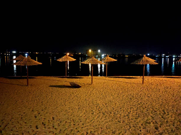 Part of the beach that is lit at night. In the distance the light of the city. stock photo