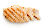 Partially sliced grilled chicken breast with grill marks, ground black pepper and salt isolated on white. Top view.