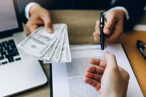 Partner has made a fraud in the contract of sale and being handed a cash and pen to the businessman signing the contract corruption bribery concept. stock photo