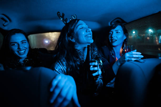 Party at the back-seat at taxi Three modern young women celebrating New Year's Eve at the back-seat of a car back seat stock pictures, royalty-free photos & images