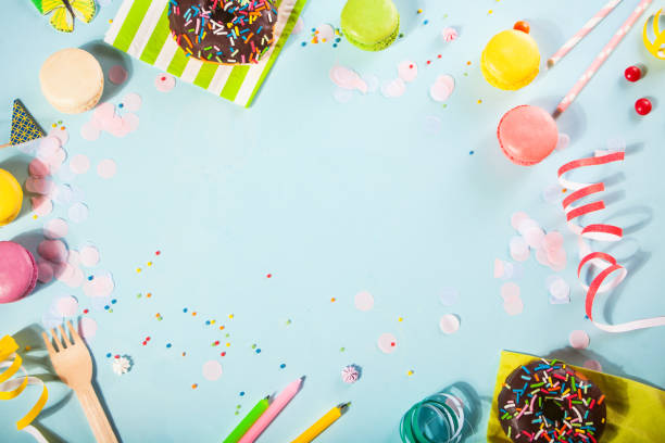 Party frame. Birthday candles, donuts, sweets, candies on the blue background. Top view. Copy space. stock photo