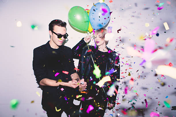 Party New Year's / Birthday Party. Girl and boy posing in front of white wall with balloons new years eve girl stock pictures, royalty-free photos & images