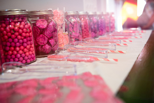 Table with jars of vibrant colored candy invoking party atmosphere.