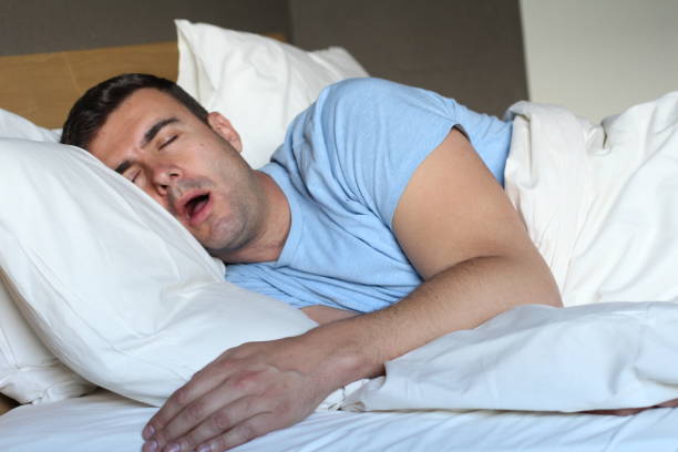 Passed out man drooling in bed stock photo