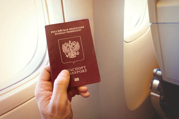 Passenger holding Russian passport on the airplane stock photo