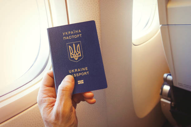 Passenger holding Ukrainian passport on the airplane stock photo