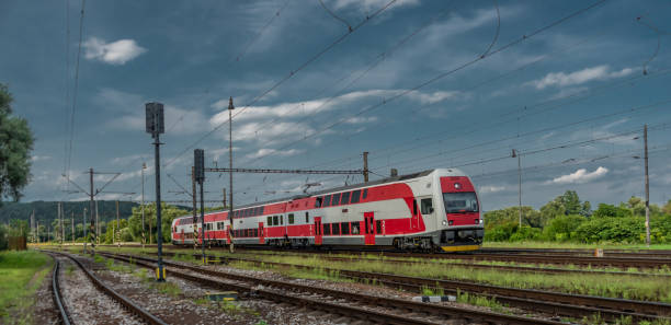 Passenger train with red electric locomotive and passenger coaches in summer stock photo