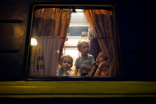 Passengers on night train in Lviv, Ukraine Lviv, Ukraine - September 6, 2016: Two young boys and a woman, presumably their mother, sit inside a train apartment moments before departing the station in Lviv, Ukraine. The train will be traveling overnight to Odessa. lviv photos stock pictures, royalty-free photos & images