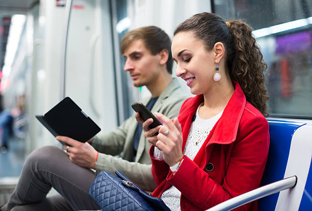 passagers dans le métro de lecture familiale - smartphone car photos et images de collection