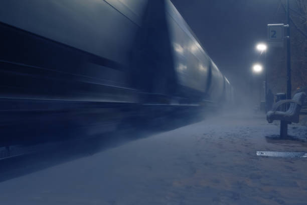 Passing cargo train in blurred motion at train station on a winter night stock photo