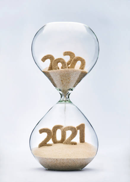 Passing into New Year 2021 New Year 2021 concept with hourglass falling sand taking the shape of a 2021 2020 stock pictures, royalty-free photos & images