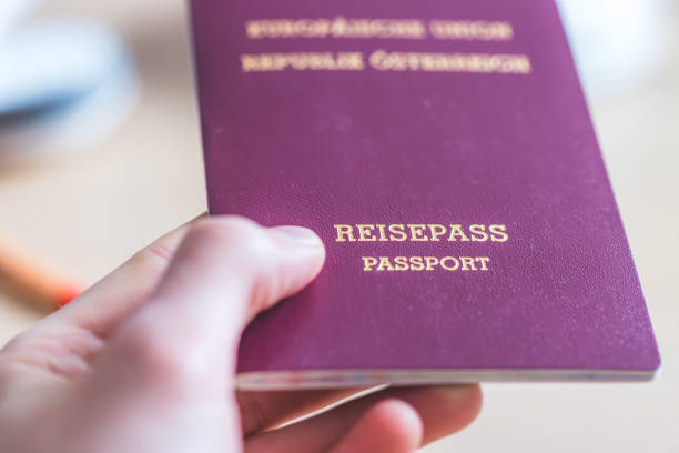 Passport vacation concept: Close up of fingers holding a passport, arrival or departure, “Reisepass Passport” stock photo
