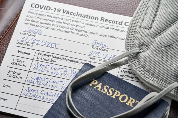 Passport with Covid-19 Vaccination card and Mask stock photo