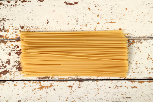 Uncooked italian pasta lumache. Isolated on a white background. Close-up.