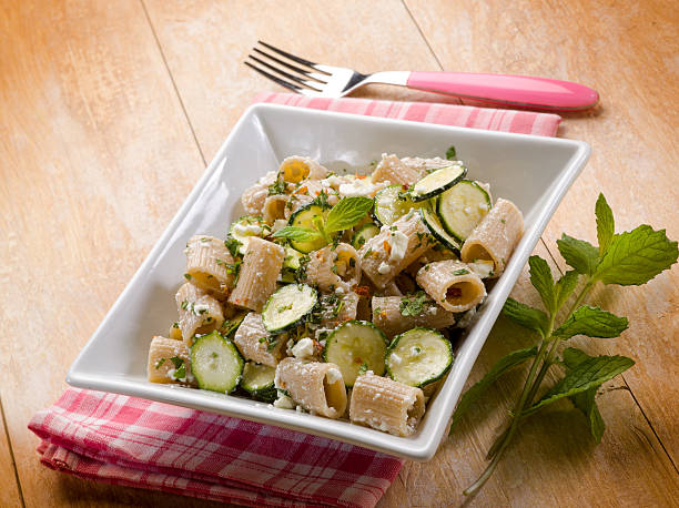 pasta with feta cheese zucchinis and mint leaf stock photo