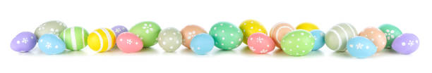 Pastel Easter eggs forming a long border isolated on white stock photo