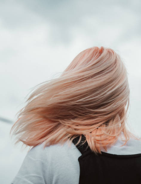 Pastel orange hair color Rear view of a woman with a blorange hair color looking up combination hair stock pictures, royalty-free photos & images