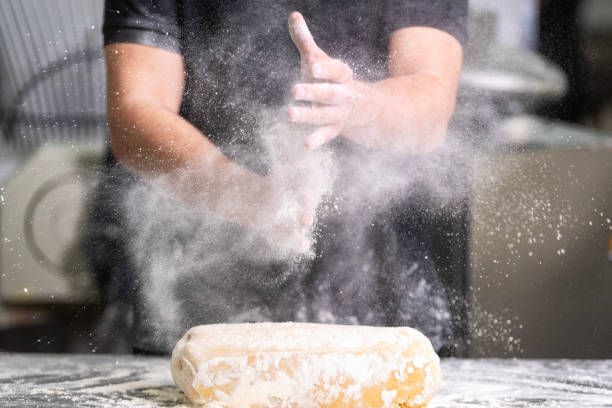 Pastry Chef clapping his hands with flour while making dough Pastry Chef clapping his hands with flour while making dough . confectioner stock pictures, royalty-free photos & images