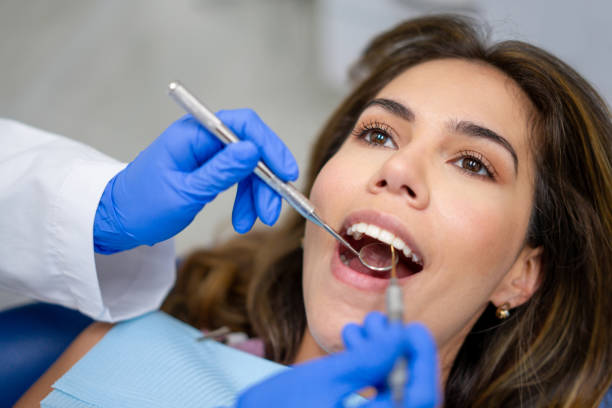 Patient at the dentist getting her teeth cleaned stock photo