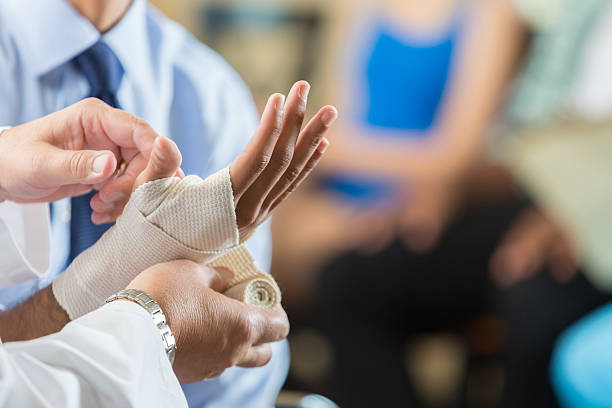 patient mit handgelenk bandagiert von krankenschwester im krankenhaus triage-center - handgelenk stock-fotos und bilder
