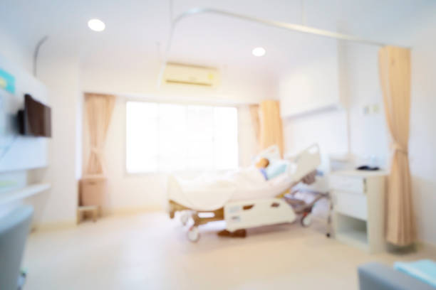 Patient on hospital bed, medical blur interior background white room ward stock photo