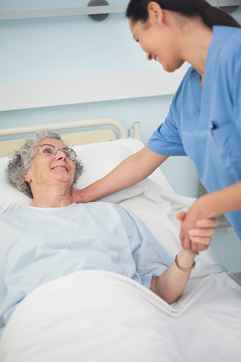 Patient Smiling To A Nurse While Holding Her Hand Stock Photo ...