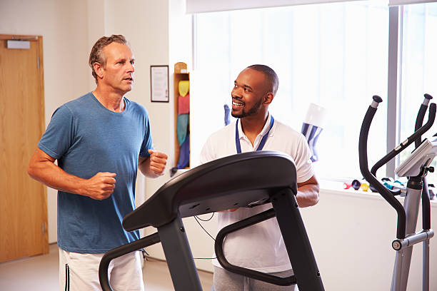 pasien menggunakan treadmill di departemen fisioterapi rumah sakit - treadmill potret stok, foto, & gambar bebas royalti
